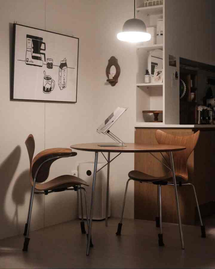 Cozy kitchen with warm wood tones featuring a round dining table and pendant light in a simple setting