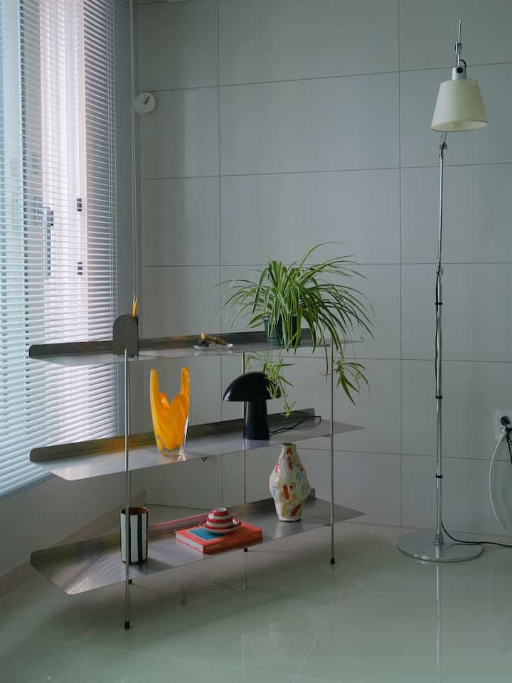 Modern living room by a window featuring silver simple-design Steel DiBeluca shelf and floor lamp