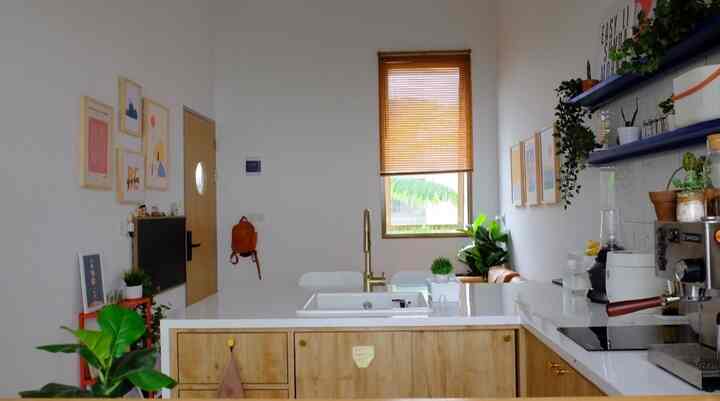Natural color and white-toned small kitchen featuring transparent partitions and a dining table for an airy interior