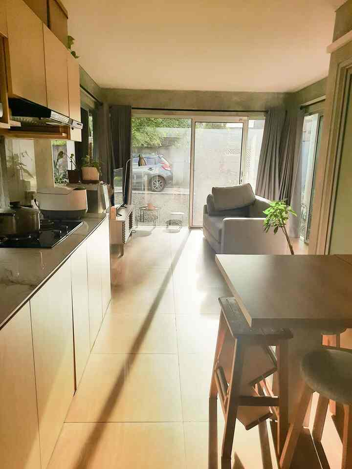 Bright open living, kitchen, and dining space in white, gray, and wood tones with simple Japandi style decor