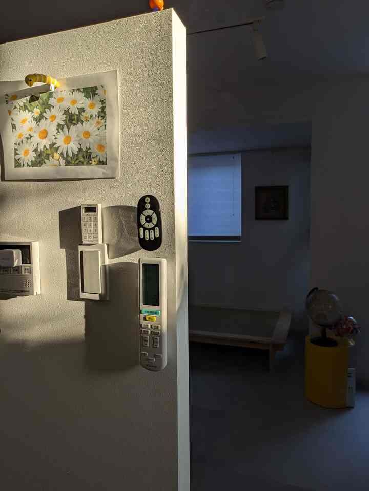 ベージュとホワイトの色調のリビングと寝室の一部が見える空間、小さな窓からの光が限られた雰囲気のあるインテリア