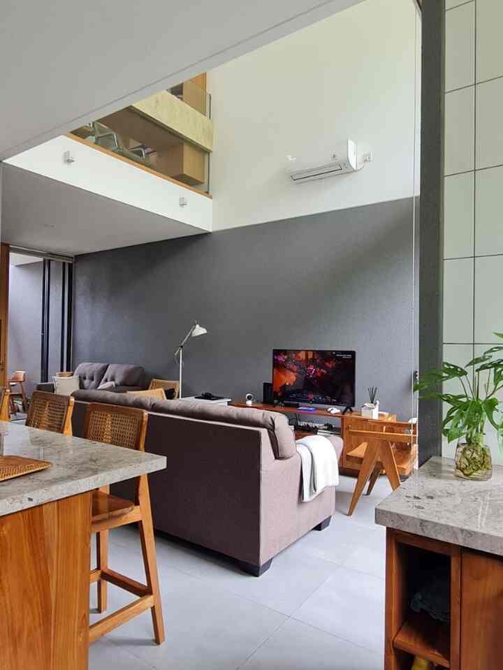 Charcoal wall and wood tone furniture compose a compact Japandi style living room space
