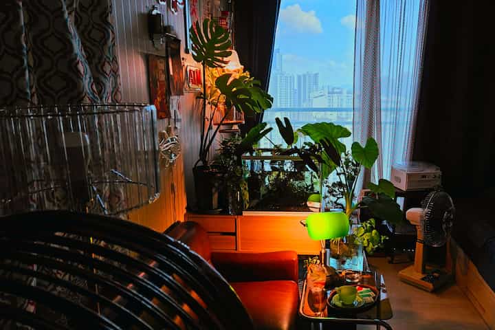 暖かいブラウンとナチュラルカラーが調和するリビング、ヴィンテージ家具と緑豊かな植物が配置された雰囲気のある空間