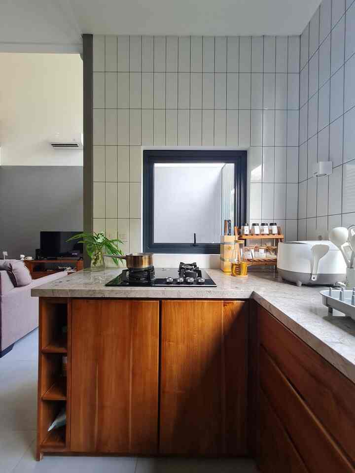 Halo teman-teman @compacthappyhome! 😄

Kami mau cerita sedikit nih soal dapur mungil kami yang ukurannya sekitar 3x2 meter. Dapur ini menyatu dengan area dining dan living, jadi terasa lebih terbuka dan lega. Bentuknya U shape, biar pas sama layout ruang dan memang dari awal sudah dirancang seperti itu sama arsitek kami.

Tapi ada cerita seru, nih! Awalnya, rencana desainnya beda. Namun, waktu lagi jalan-jalan, kami tanpa sengaja lewat di depan toko furniture yang men-display kitchen set kayu jati yang langsung bikin kami jatuh cinta. Jadilah, rencana berubah!

Karena kami memang suka tampilan natural, akhirnya kami pakai bahan-bahan alami di dapur. Meja dapur dan wastafel kami pilih yang berbahan granit. Selain kuat dan tahan lama, granit juga memberi sentuhan elegan tapi tetap terasa hangat dan alami.

Untuk kitchen cabinet, kami pilih kayu jati dengan desain simple tanpa handle, biar kesannya sleek dan modern. Kami cuma pakai kabinet bawah aja supaya ruang terasa lebih lapang. Sementara itu, backsplash-nya kami pakai keramik subway putih yang klasik. Hasilnya? Tampilan bersih dan timeless!Bentuk U shape ini benar-benar pas buat memaksimalkan ruang sekaligus bikin alur masak jadi lebih nyaman. Oh ya, kami juga pisahkan sedikit dapur dari area makan supaya tetap terasa lega dan nyaman.

Di area dining, kami pakai island table dari kayu jati yang dipadukan dengan top table granit yang senada sama kitchen. Jadi, semuanya terlihat selaras, deh.

Gimana menurut kamu, dapur U shape kami? Yuk, share pendapatmu di kolom komentar! 🍃🍽️

#CompactHappyHome #KitchenDesign #GraniteCountertops #TeakwoodCabinets #NaturalMaterials #UShapekitchen #MyDreamKitchen #IdeDekorDapur #KitchenMaterials #HomeInspiration 