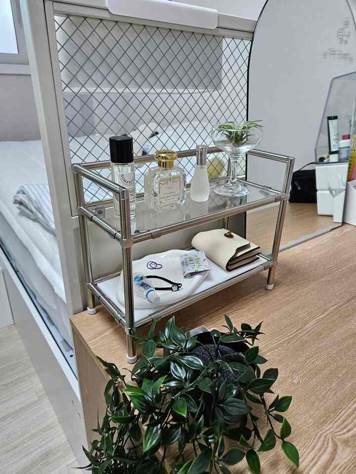 ホワイトと木目調が調和したコンパクトな空間の化粧台、ステンレス棚と植物、鏡が整然と配置されたインテリア