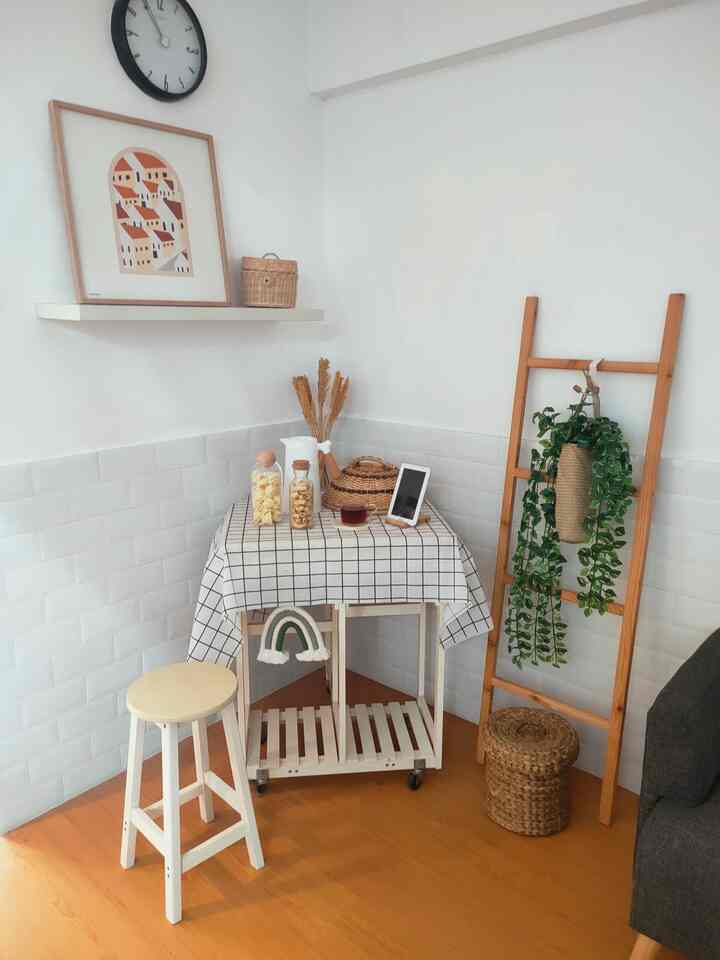 Compact dining room with white walls and light wood flooring featuring a foldable dining table and natural decor elements in a natural modern style