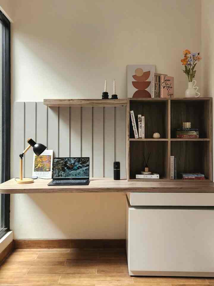 White and brown toned compact home office featuring solid wood desk and bookshelf with modern warm atmosphere