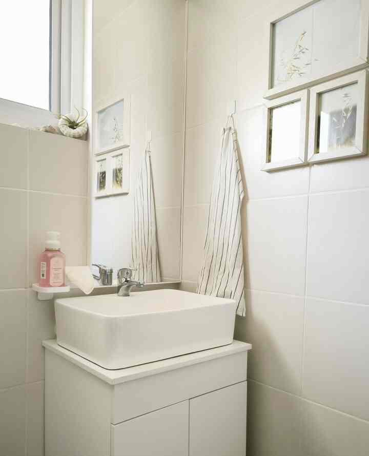Bright white tone bathroom featuring a wash basin cabinet and striped towel for a clean look