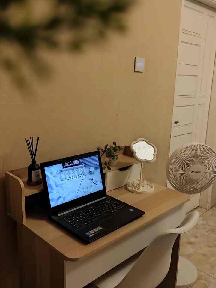 Beige-toned wall and wood-tone desk in a simple home office space
