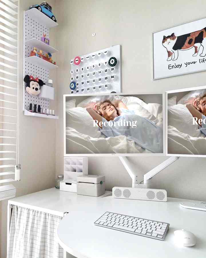 ホワイトトーンのホームオフィス、綺麗なデスクにデュアルモニターと整理された小物が配置された雰囲気のある作業空間