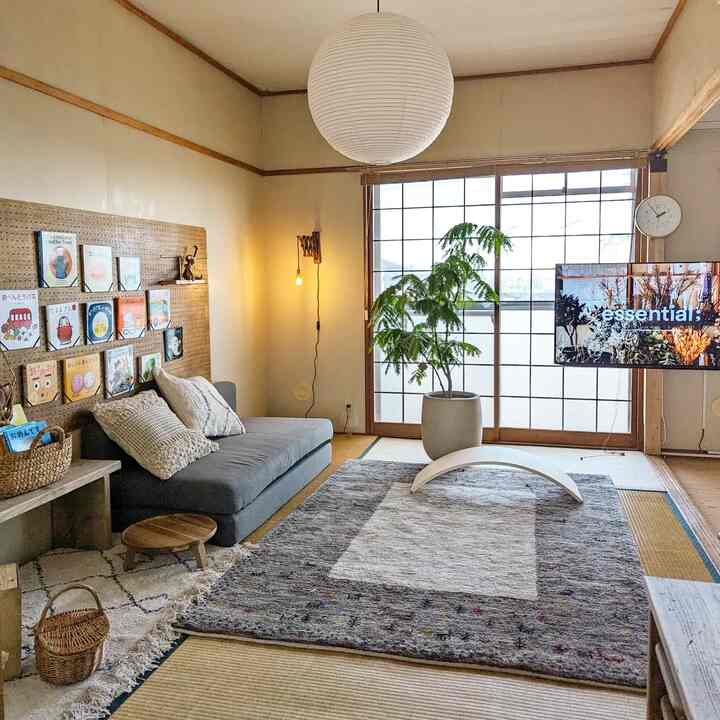 ナチュラルな色調の和モダンリビング、グレーのソファと大きな畳ラグが配置された伝統と現代が融合した印象的な空間