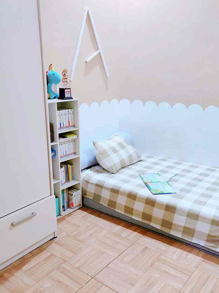 Small bedroom in white and beige tones featuring a bookshelf and single bed with a simple design