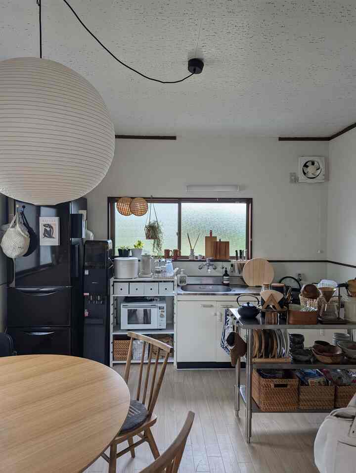 ナチュラルな色調のキッチンとダイニングテーブルが配置された、落ち着いた雰囲気のあるインテリア