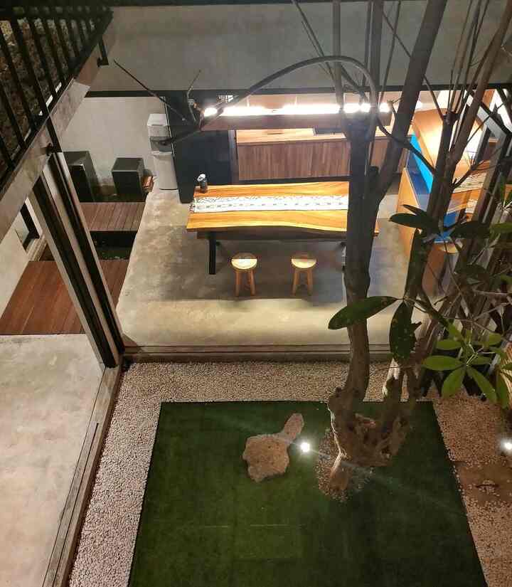 Ruang makan diciptakan dengan gaya santai ala-ala warung wedangan.Dengan meja makan besar yang terbuat dari kayu trembesi solid, dibuat secara custom dengan tetap mengambil gaya industrial.Sudut meja dibuat tumpul supaya tidak membahayakan anak-anak.
Pintu jendela lipat di tiga sisi ruang makan,bisa dibuka lebar supaya menyatu dengan taman tengah.Menjadikan anak-anak bebas beraktivitas sembari menikmati cemilan yang tersedia di meja makan.
Selain ruang makan keluarga,ruang ini kami alih fungsikan sebagai ruang jamuan ketika ada pertemuan keluarga.Aliran udara yang masuk dari void menjadikan area sekitar ruang makan tidak pengap meski banyak orang.
Dengan mempertahankan kesan minimalis,menjadikan ruang makan terasa luas dan anak-anak bebas beraktivitas 
#kayutrembesi #semen #alumunium #mejamakanminimalis #inspirasiRuangMakan #DiningroomStyle