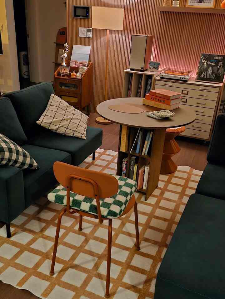 温かみのあるナチュラルモダンなリビング、緑色のソファと丸いコーヒーテーブルが配置された雰囲気のある空間