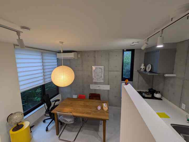 白と茶色の調和が美しいモダンなダイニングルーム、木製のテーブルとペンダントライトが配置された印象的な空間