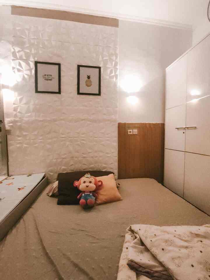 Natural wood tone and white kids' bedroom featuring a stuffed toy and cozy bedding with warm, inviting atmosphere