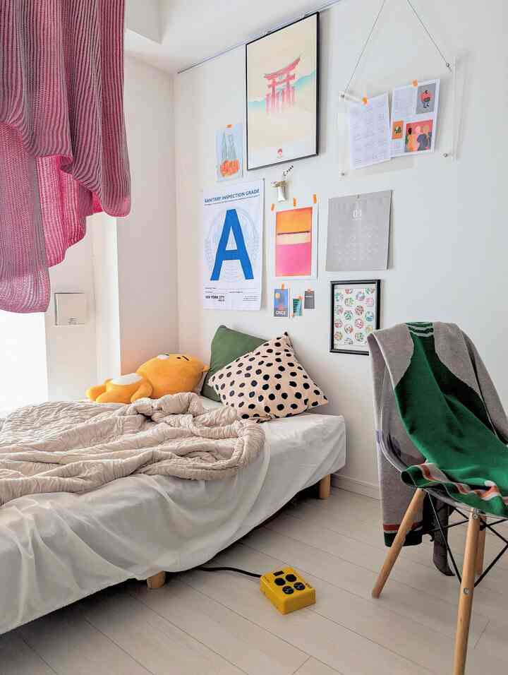 White and beige toned bedroom featuring pillows and art posters creating a cozy atmosphere