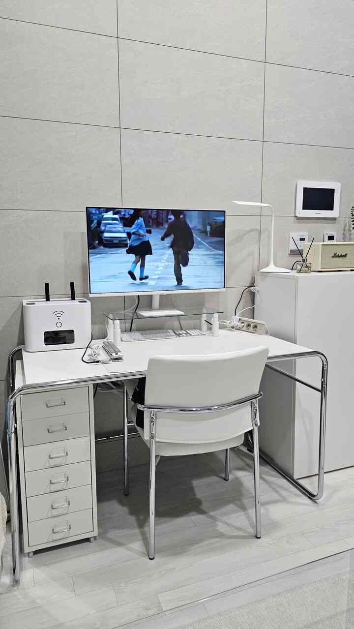 グレーのタイル壁と白いデスク、椅子が配置されたシンプルなホームオフィスの空間