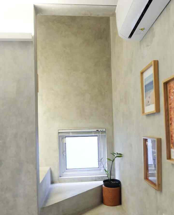 Natural color walls and a compact area under stairs with picture frames and a plant