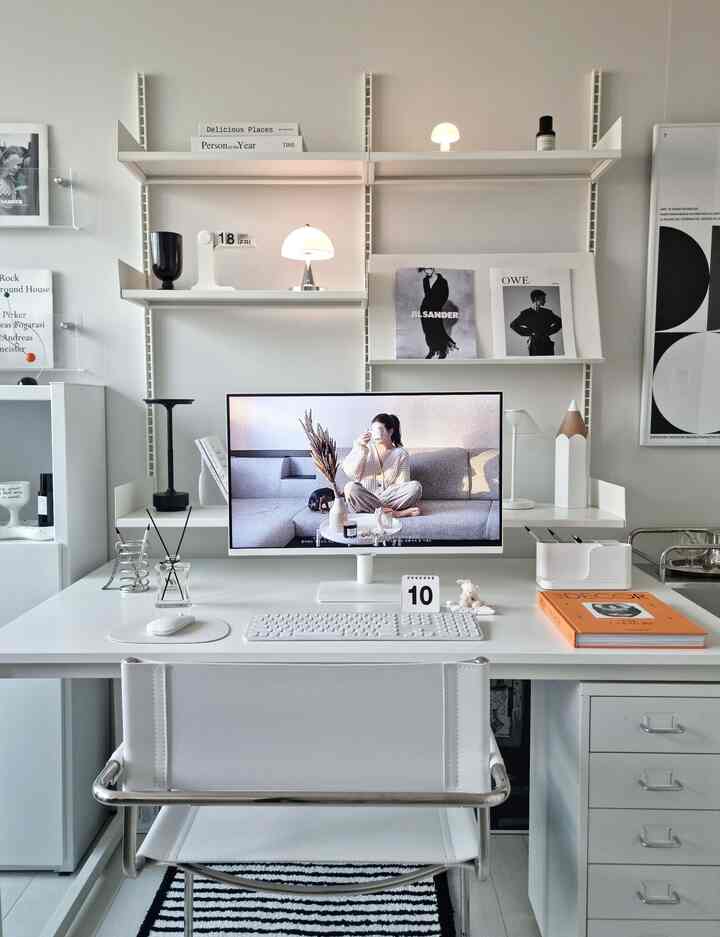 白を基調とした書斎空間、ミッドセンチュリーモダンのデスクとチェア、壁棚と照明小物が配置された清潔感のあるホームオフィス