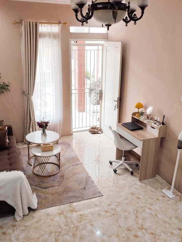 A small living room and home office space with beige walls and white furniture, creating a cozy and tidy atmosphere