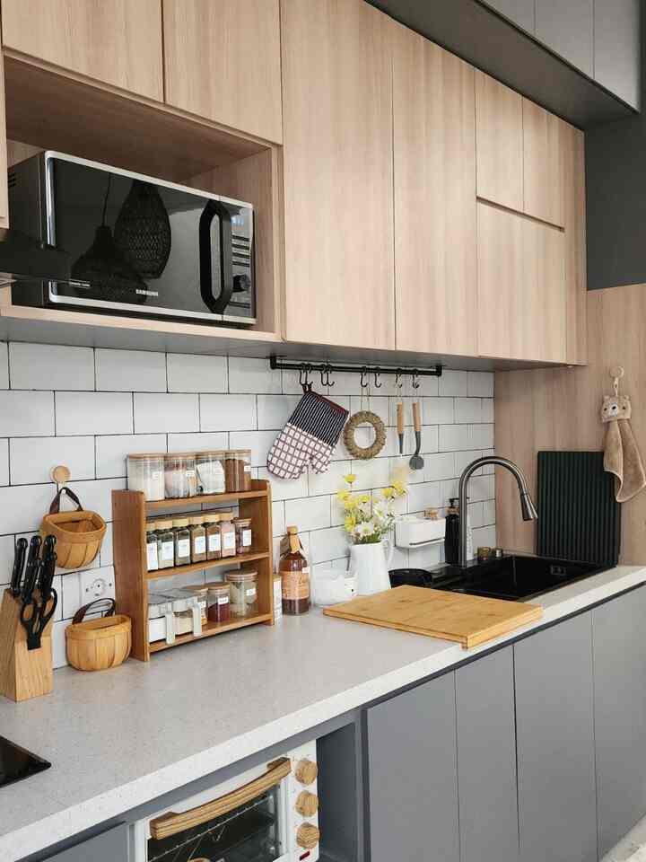 Wood tone and white kitchen space featuring organized kitchen utensils and a LÄMPLIG cutting board, creating a neat and cozy atmosphere