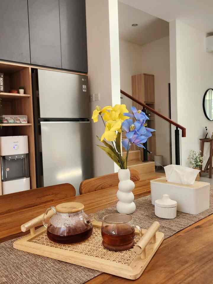 Natural-toned kitchen and dining room featuring wooden dining table with home cafe accessories creating cozy atmosphere
