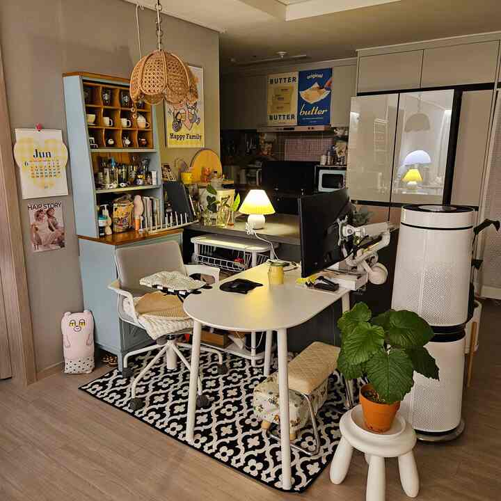 ホワイトとブラックのトーンのリビングルームホームオフィス、楕円形のデスクと椅子、本棚、空気清浄機が配置された雰囲気のある作業空間