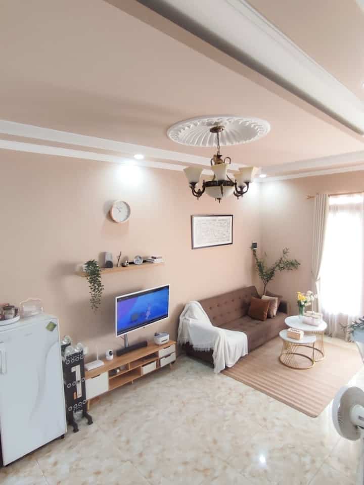 Warm beige-toned living room featuring a brown sofa and round coffee tables creating a cozy atmosphere