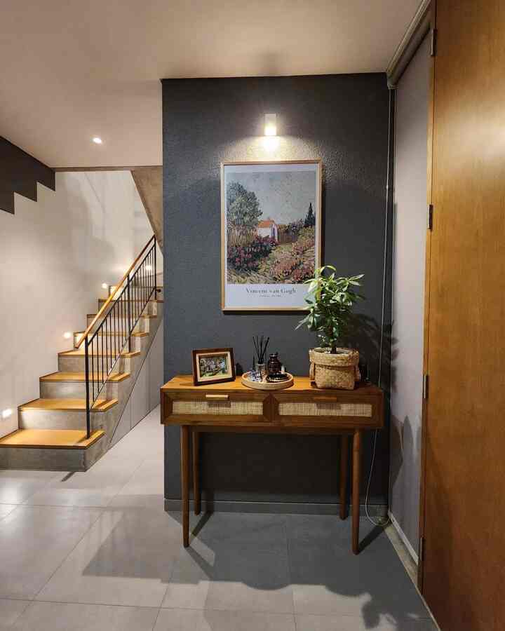 Foyer yang simpel namun hangat ini memberikan kesan pertama yang tak terlupakan saat masuk ke rumah. 

Dengan meja foyer custom dari kayu jati yang kompak, area ini diubah menjadi sudut yang fungsional sekaligus estetis. 

Kami pasangkan meja foyer dengan sofa dua dudukan dan satu meja samping dari kayu jati, menambah sentuhan alami dan klasik. 

Tak lupa, kehadiran anggrek cantik di area ini memberikan kesegaran dan suasana yang lebih welcoming. 

Kesederhanaan yang dipadukan dengan elemen kayu membuat foyer ini menjadi tempat yang hangat dan nyaman untuk menyambut tamu.

#CompactHappyHome #FoyerNyaman #Ruangterbatas #Nevertoosmall #DekorasiRumah #Mejafoyerjati #Warnacatrumah #wallpaperdinding #cat