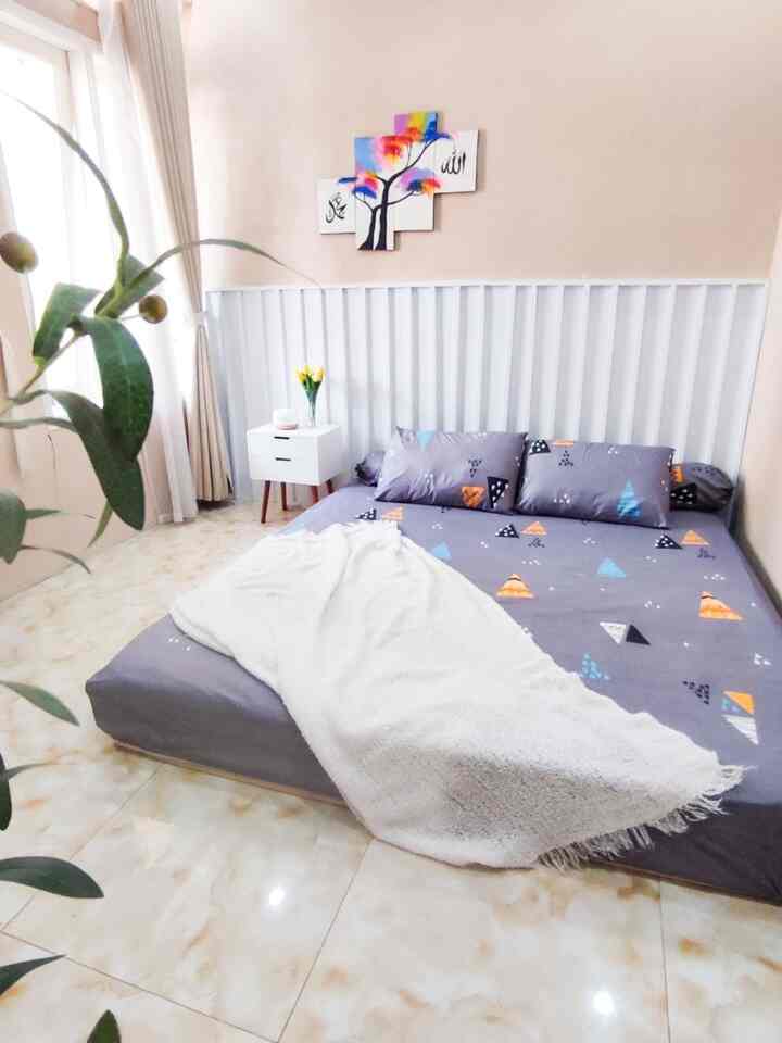 Beige-toned bedroom featuring white bedding and a nightstand designed for 4-person occupancy