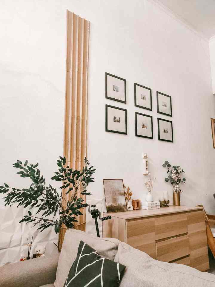 Natural tone living room featuring wood tone sideboard and plants in a simple, warm space