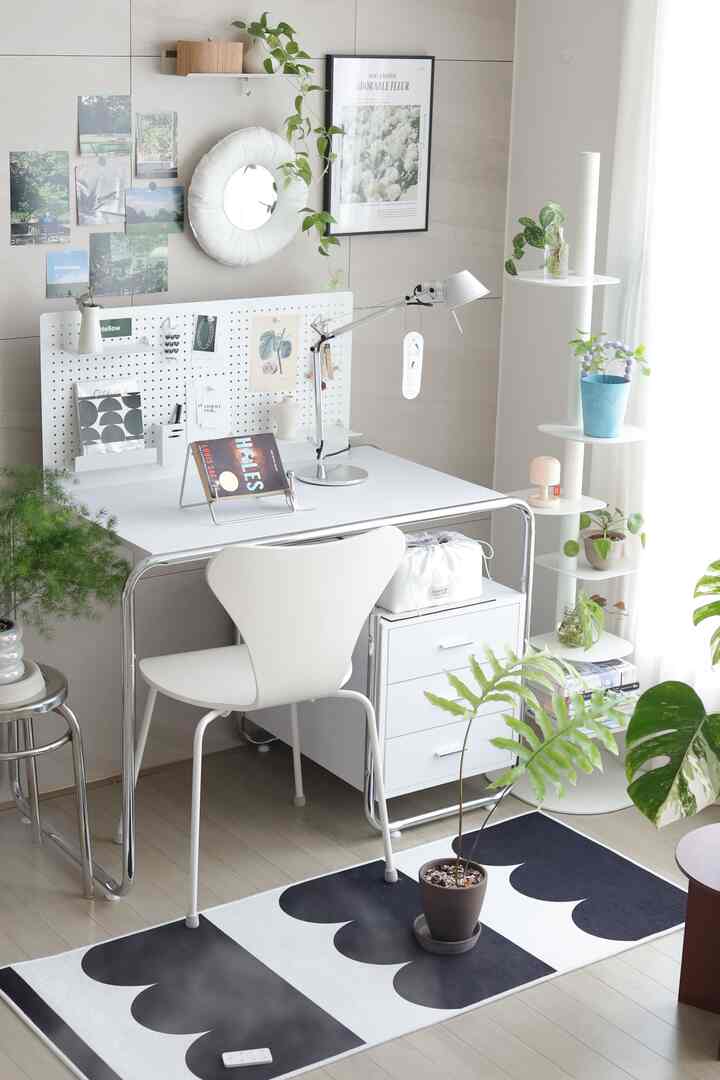 白と緑の色調の小さなホームオフィス、シンプルで清潔感のある机と植物の飾り付けが調和する印象的な空間