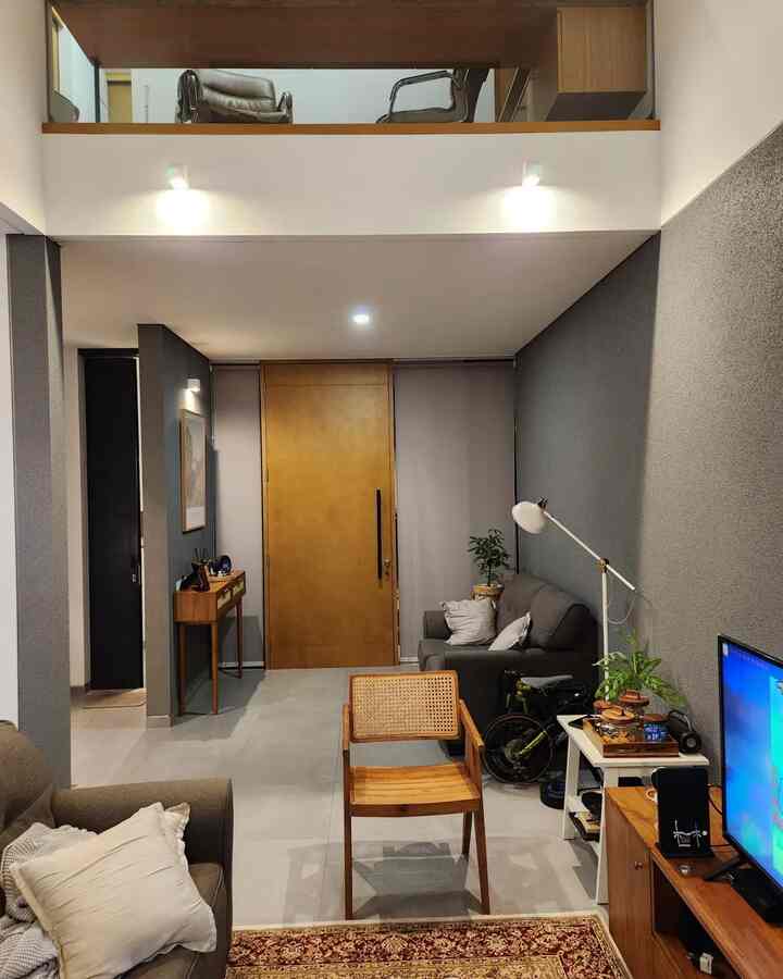 A modern living room with harmonious wood tones and grays, featuring simple furniture and warm lighting