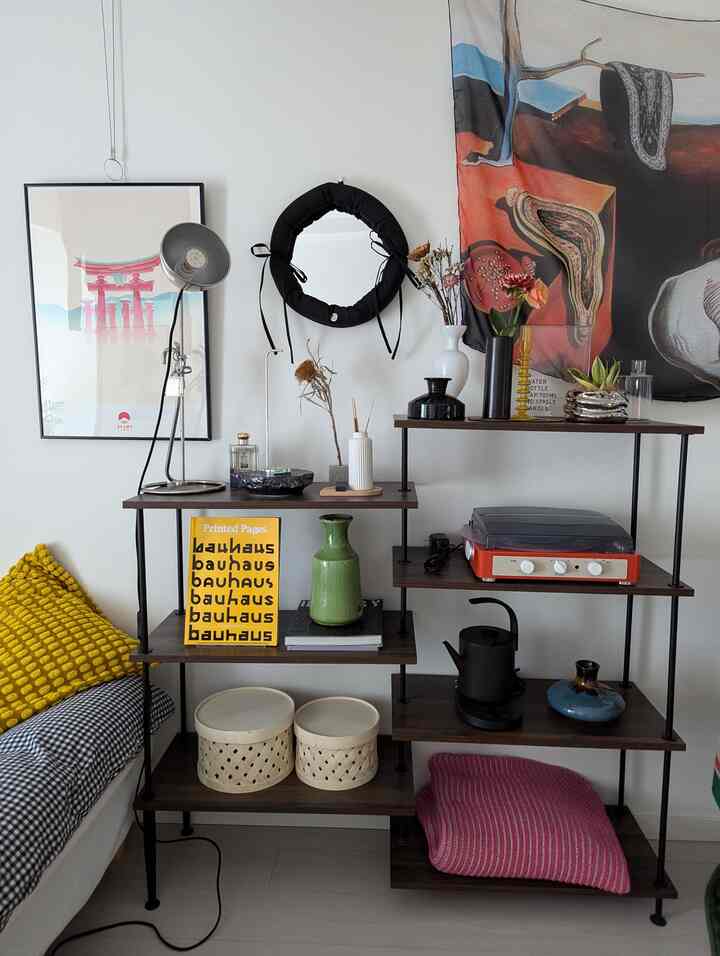 赤と茶色のトーンのリビングルーム、ソファ、ポスター、花瓶が置かれた棚、ヴィンテージレトロの雰囲気のあるインテリア