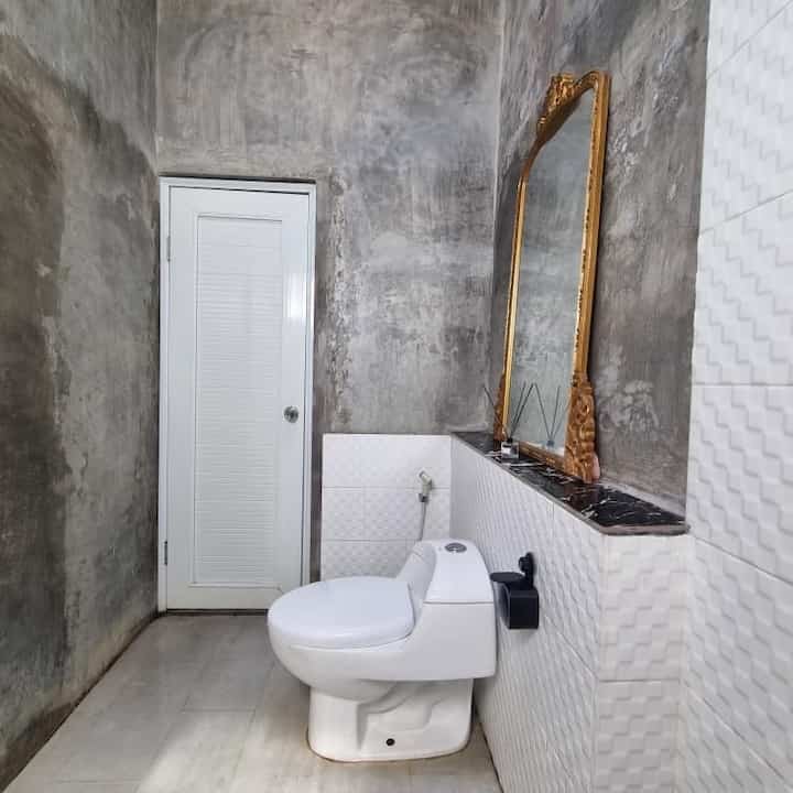 Kamar mandi di #RumahAngsoka menggabungkan tembok exspose dengan keramik putih motif. Pada atap kamar mandi kami menggunakan dak beton dengan skylight posisi di tengah, agar cahaya ilahi dan sirkulasi udara keluar masuk dengan baik. 

Tampilan kamar mandi kami menggunakan pintu PVC putih dengan wastafel terazo sebagai pemanis dan pelengkap pada area kamar mandi outdoor kami. 
-
• Ukuran kamar mandi : L 1.5m x 2.5m
• Pintu Kamar Mandi : 
BAHAN PVC SUDAH + HANDLE PINTU NYA DAN KUNCI 
UK 80 X 2 METERAN

#KeramikKamarMandi #ClosetKamarMandi #KeramikDinding #KamarMandiIndustrial #TempatSabun #DispenserSabun #DindingExpose #DindingKamarMandi #PintuKamarMandi #KamarMandiMinimalis #InspirasiKamarMandi