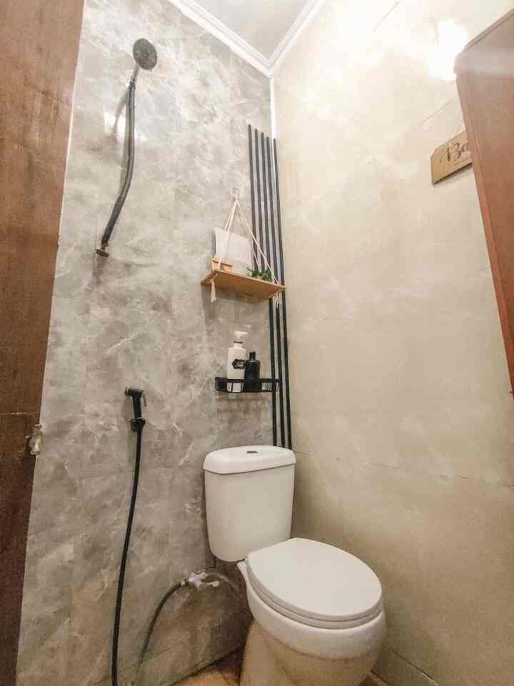 Small bathroom with gray marble wallpaper and white toilet, featuring a clean and modern atmosphere
