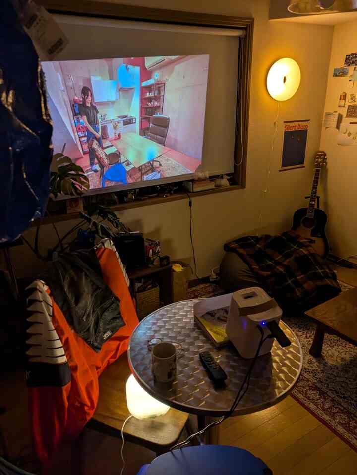 Warm wood tone and brown 1K single household space featuring mid-century modern bean bag and projector in a cozy home cinema setup