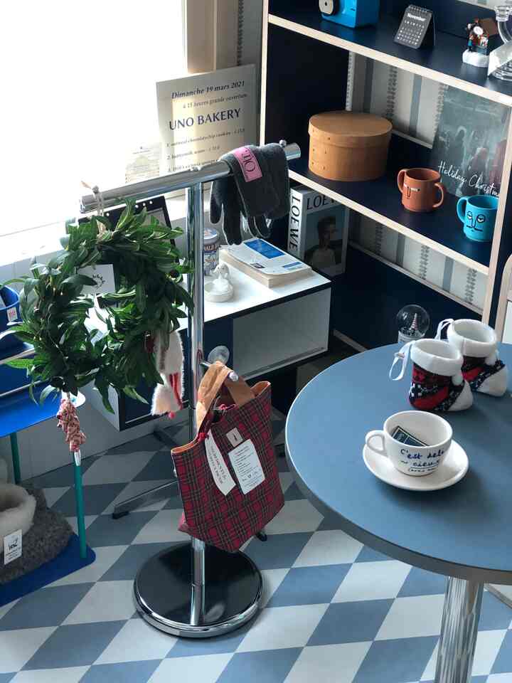 ブルーと木目調のダイニング、円形テーブルとコートラックが配置された雰囲気のあるカフェ風インテリア