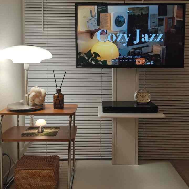 Cozy small living room for a single household featuring natural wood tone furniture and table lamps