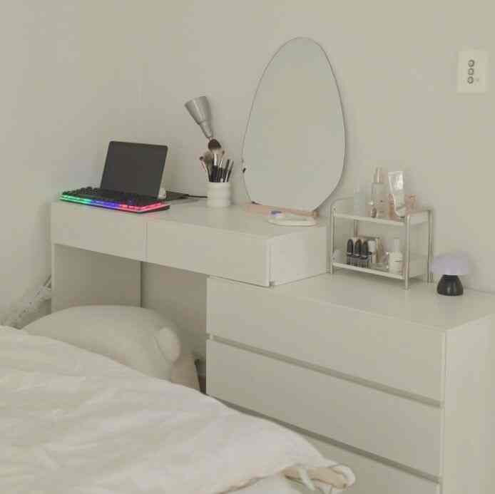 White-toned bedroom space featuring a vanity with stool and a neat home office setup