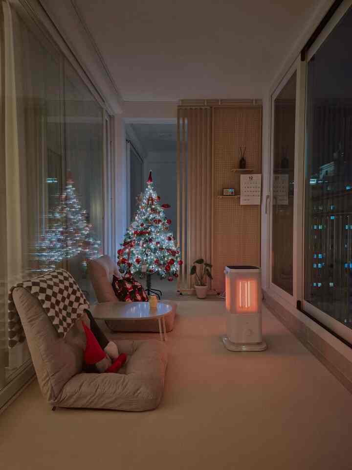 白と赤の色調が調和した狭いベランダ、座椅子とクリスマスツリーが配置された雰囲気のあるインテリア