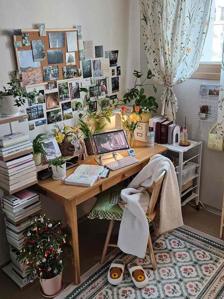 ナチュラルな木目調と緑の植物が調和する、小さなホームオフィスのデスク空間。雰囲気のある居心地よいインテリア。