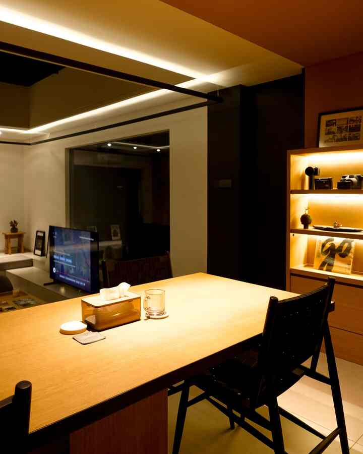 Warm wood-toned dining room featuring a large dining table and chairs with simple, cozy lighting