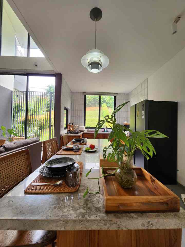 Natural color kitchen and dining room featuring large windows and modern, spacious atmosphere