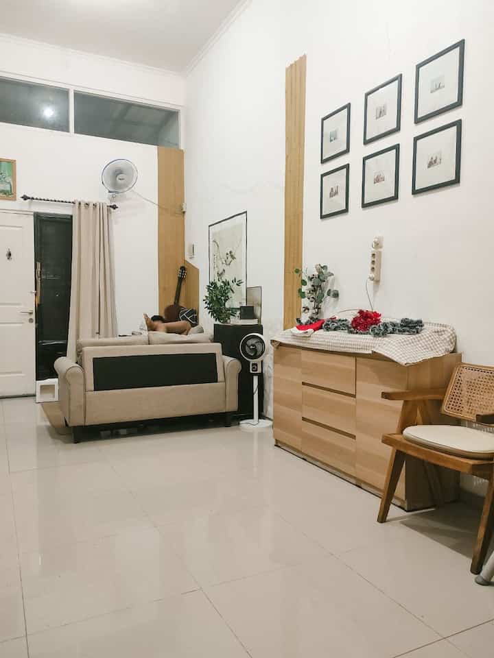 White and wood-tone living room featuring beige sofas and wall art with a simple, cozy atmosphere