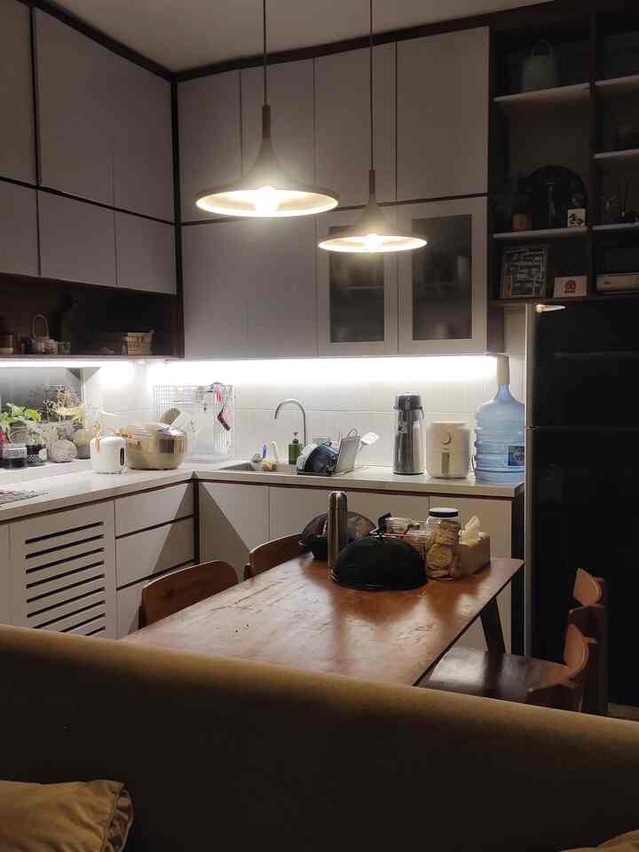 Dalam kurun waktu kira-kira 1 tahun tidak terlalu banyak perintilan yang bertambah. Dan inilah foto nuansa malam hari ini, di mana kami menata secukupnya, sedikit berantakan tak masalah.
foto kedua adalah foto 1 tahun yang lalu. 
Karena rumah kami jauh dari warung makan, hampir tiap hari kami memasak. Setahun terakhir barang pecah belah bertambah, kami akhirnya memutuskan untuk menambah rak putih di ujung dapur kami. Perubahan lainnya hanyalah perubahan tatanan layout elektronik saja. 
#KitchenSet #Kitchensetminimalis #dapurmodern #lampugantung #airfryer #hplputih #lantaisemen #alatmasak
#MyDreamKitchen #KitchenRenovation #KitchenStyling 