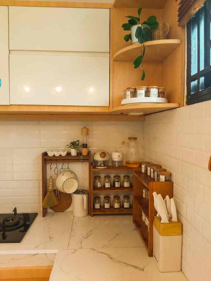 Natural color and white tiled kitchen featuring wooden shelves with storage ideas creating a clean, organized space