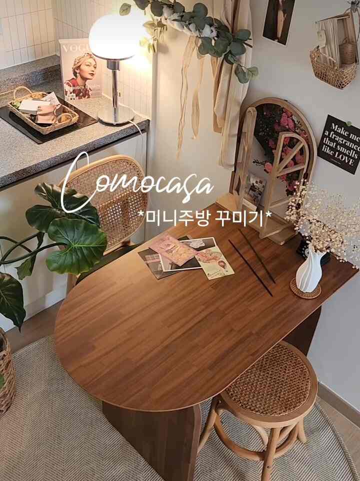 ナチュラルな木目調のミニキッチンダイニング、アーク型の木製テーブルとラタンチェアが配置された雰囲気のあるインテリア